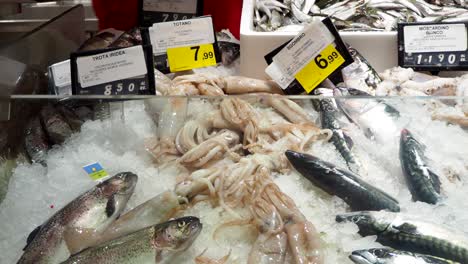 fishmonger picking squid fish at the fish market