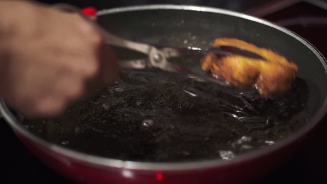 mujer sacando rabanadas de una sartén caliente para drenarlas en toallas de papel - cerrar