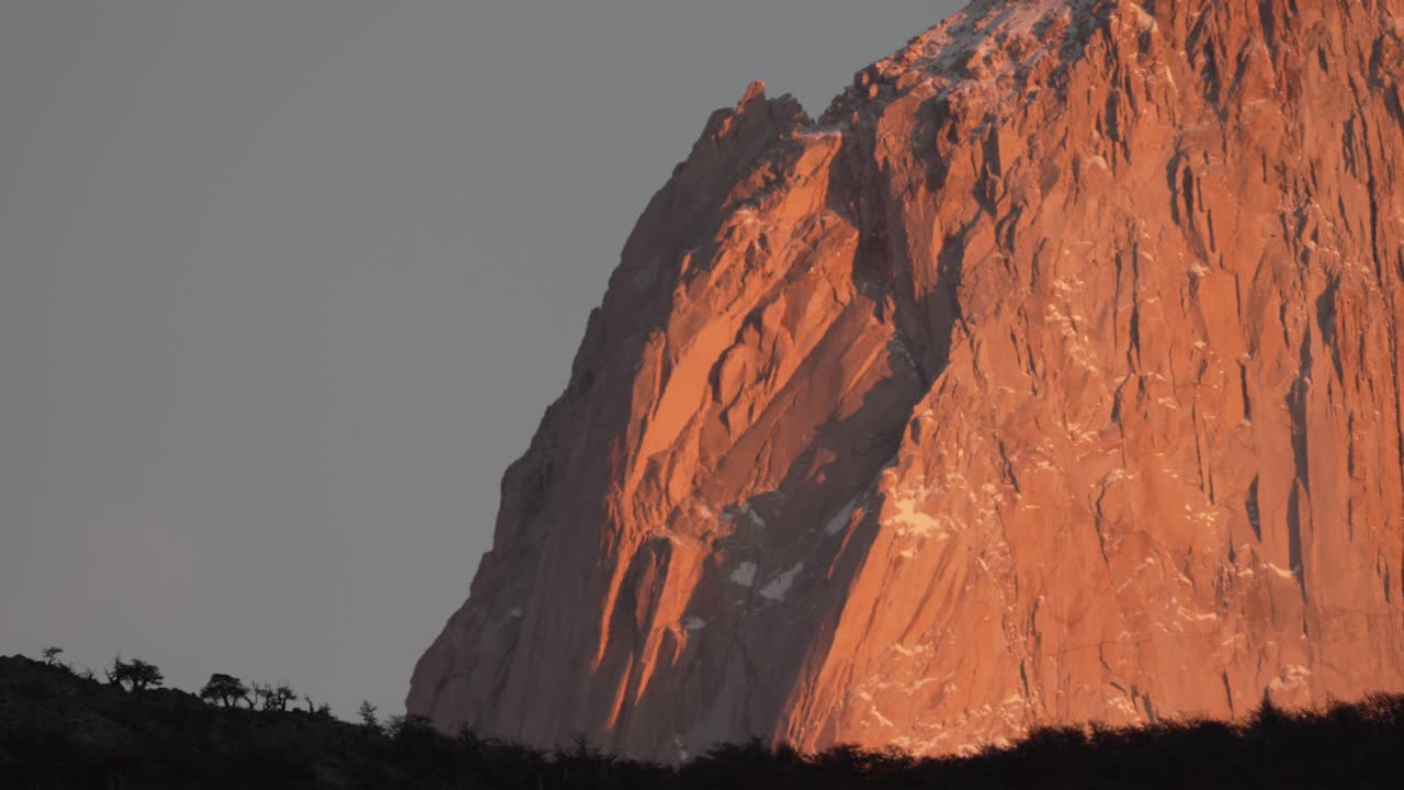 vista de telefoto del monte fitz roy con paredes de granito naranja y bosque en primer plano al amanecer