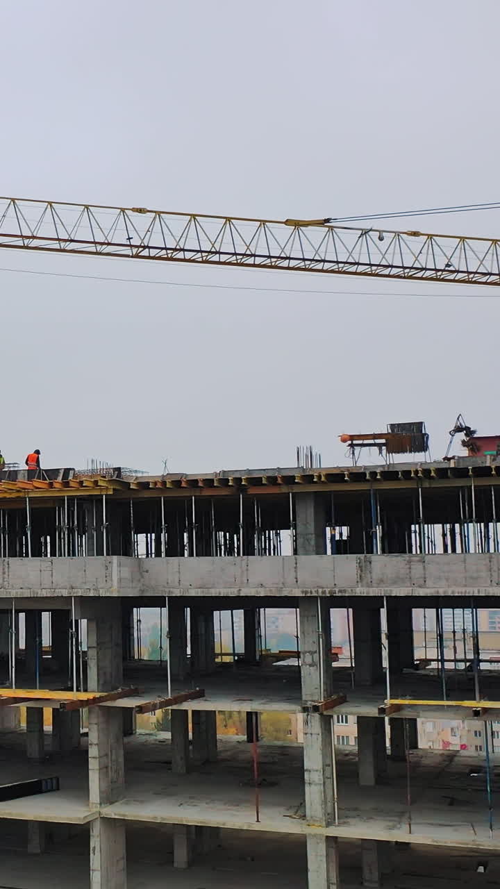 Construction site in a megacity. Video shooting with drone. New house in a residential complex. Motion camera back. Vertical video