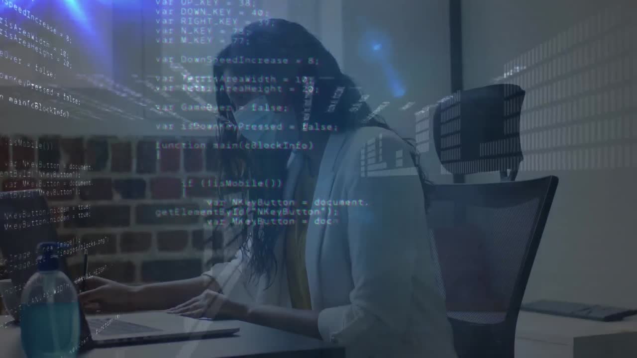 Databehandling mot en indisk kvinne med ansiktsmaske som tar notater på kontoret.