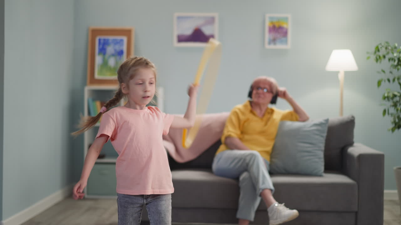 little blonde girl in a pink T-shirt is spinning a hoop