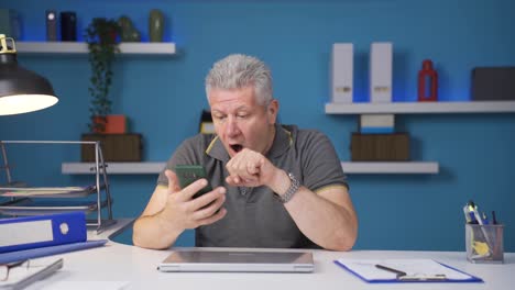 home office worker man getting good news on the phone.