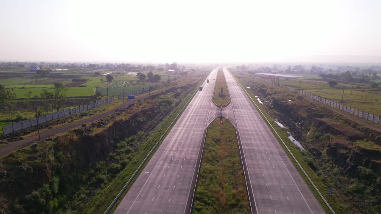 Mumbai Nagpur Expressway through agricultural fields under dense hazy sky due to air pollution, Maharashtra, Drone shot