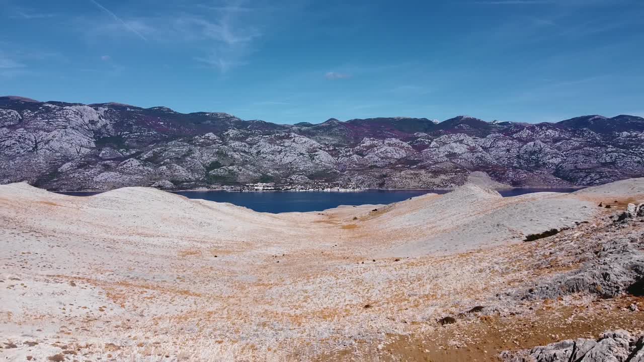 desierto de montaña rocosa con el mar en el medio
