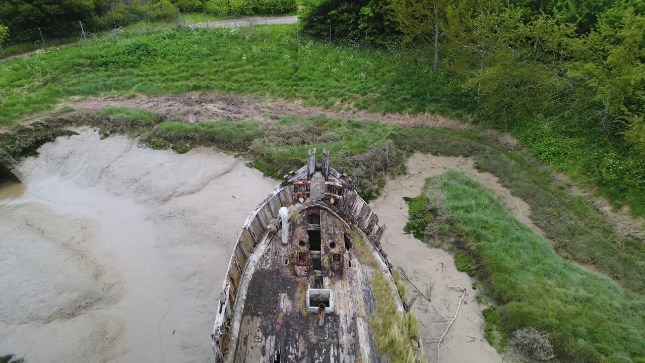 vista aérea de un barco abandonado atascado en el barro en el parque de campo wat tyler, basildon, reino unido - marcha atrás, inclinación, drone c