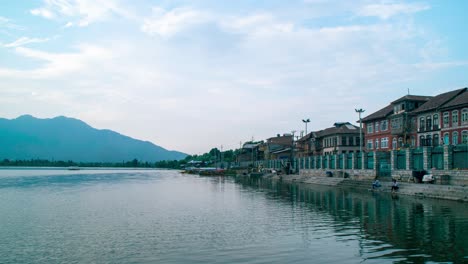 Timelapse-of-houses-near-a-large-lake-with-cloud-movement-in-the-sky-and-some-people-fishing