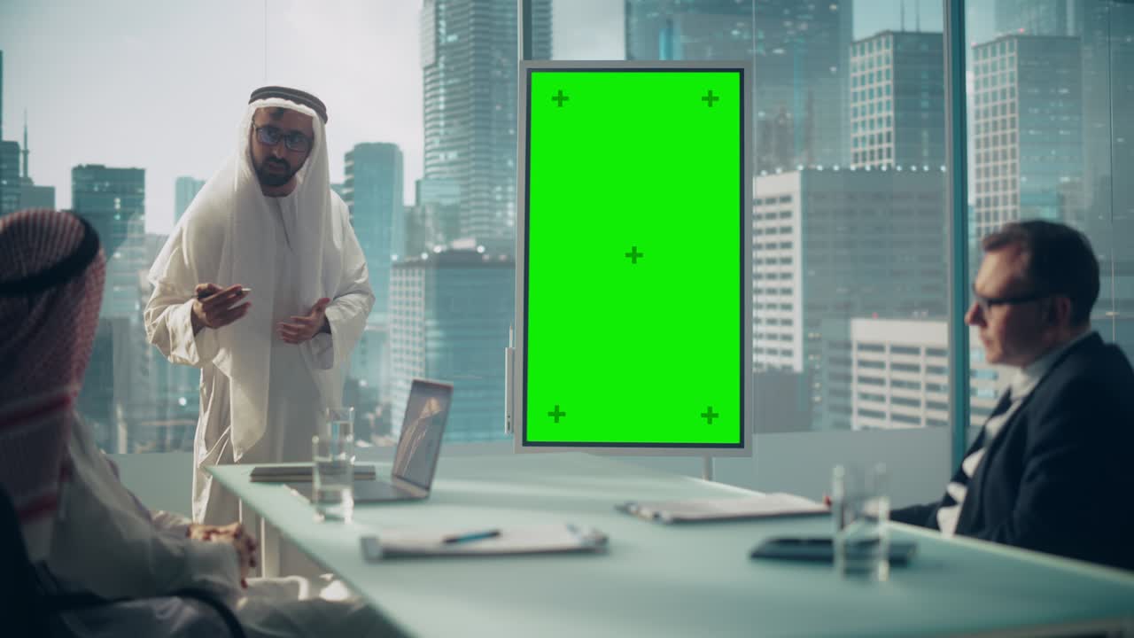 el empresario saudí realiza una presentación de reunión para socios comerciales internacionales. el gerente árabe utiliza una pizarra digital con una pantalla verde vertical para mostrar el concepto de oficina árabe.