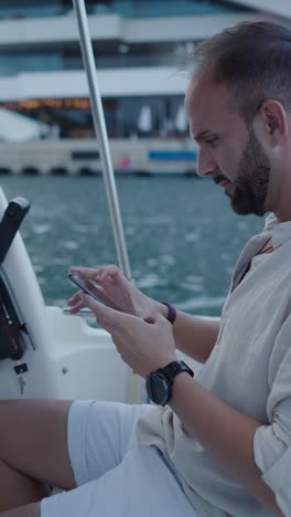 man using a phone on a boat