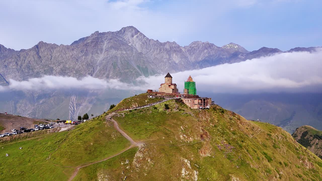 Mountain top landmark orthodox Christian chapel with scenic alpine peaks, caucuses, Georgia