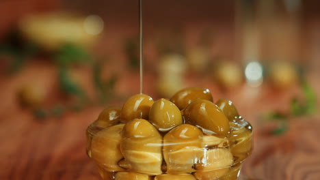 pouring olive oil over olives