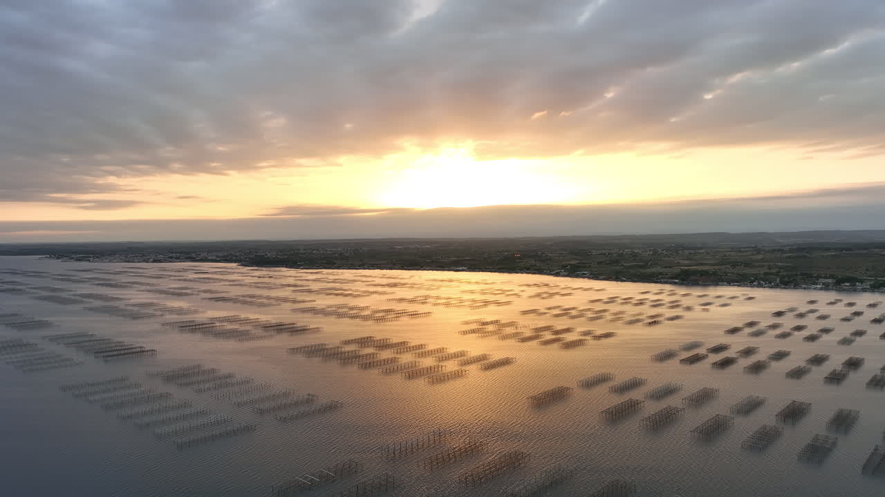 해가 지는 날 에 공중 에서 볼 수 있는 모습: 에탄 드 타우 는 금색 으로 반이고, 오이스터 는