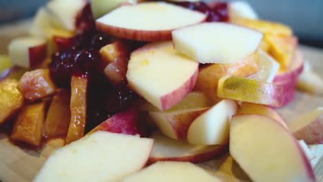 Rotating-view-of-a-pile-of-fresh-fruit-on-a-wooden-board