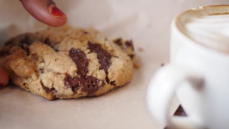 woman eating chocolate chip cookies with latte