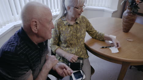 elderly couple checking blood pressure at home