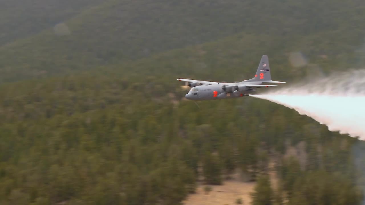 un c130 practica gotas de agua sobre un bosque en colorado
