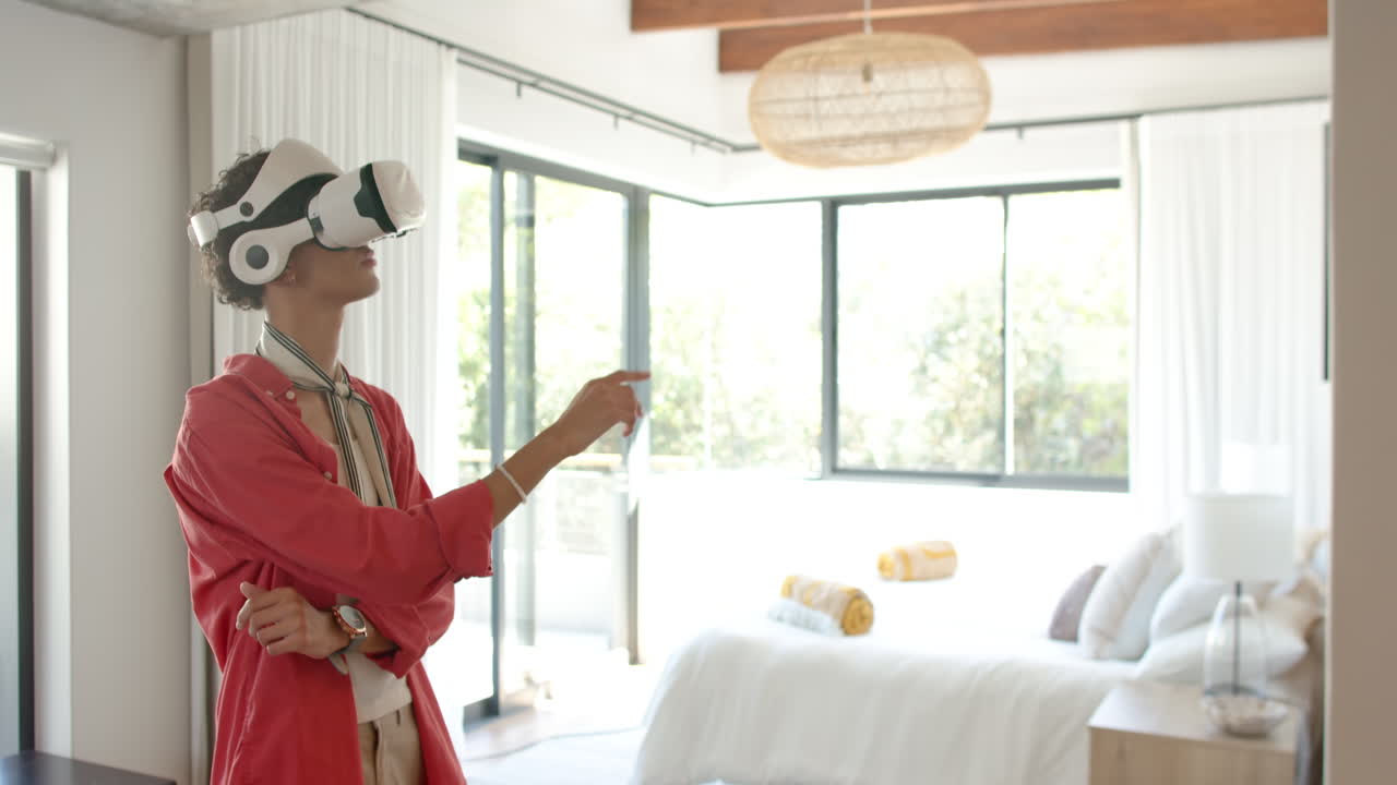 Ragazzo adolescente con un visore VR, in piedi in una camera da letto moderna, che esplora la realtà virtuale.