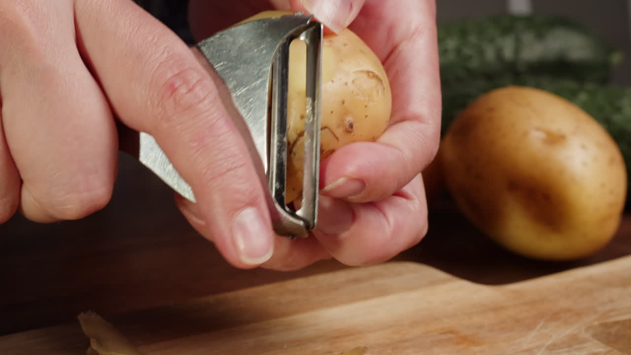 Close-up of Hands Peeling a Fresh Potato with a Peeler