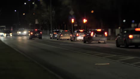 cars drive at night in an urban environment