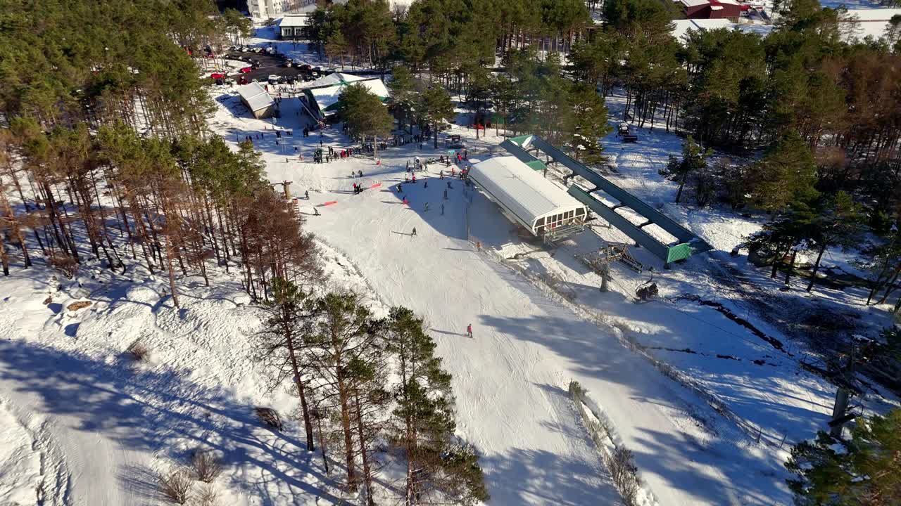Drone-luchtfoto van skiresort Manzaneda in bedrijf, te midden van een besneeuwd landschap en bomen die herstellen na recente bosbranden in Galicië, Spanje