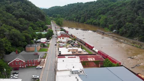 4k aerial drone video of a freight train passing through downtown marshall, nc along the french broad river (2021)