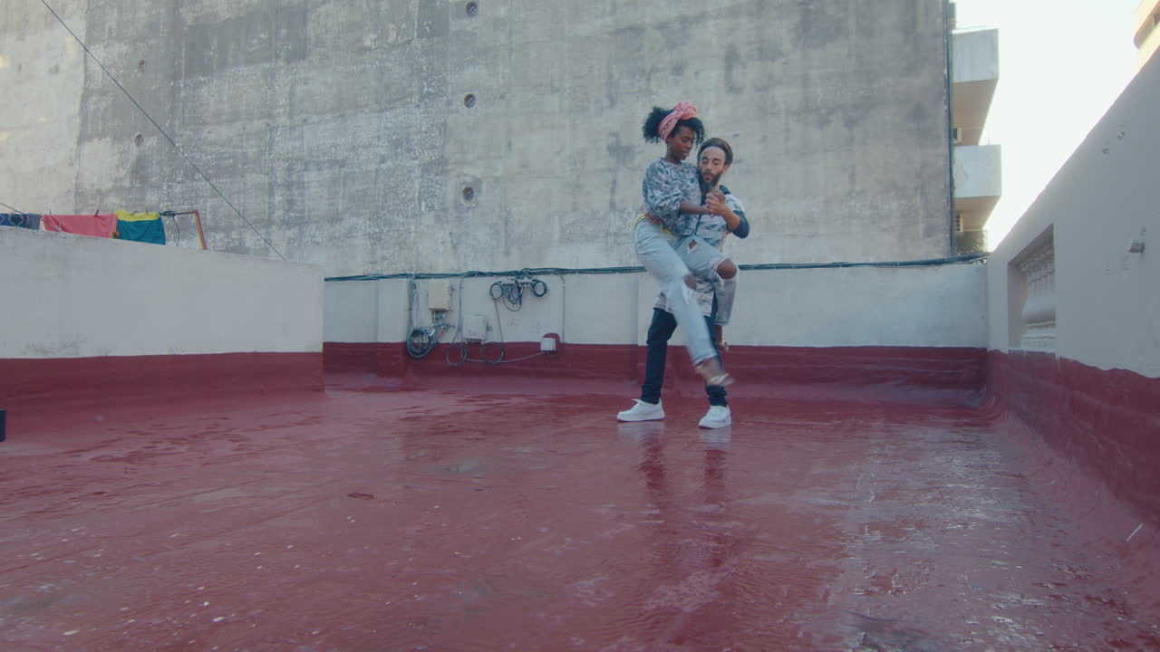 Artistic Couple in Streetwear Dancing Tango on Urban Rooftop