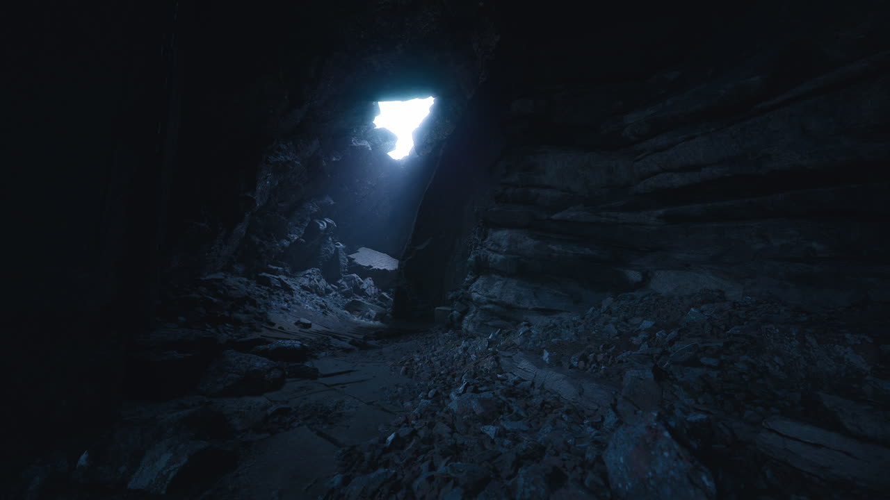 Light filters through a dark cave revealing rocky terrain and shadows