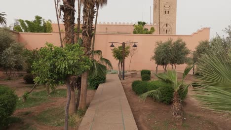 Nach-Oben-Schwenkender-Blick-Auf-Die-Koutoubia-Moschee-Mit-Gehweg-In-Marrakesch,-Marokko