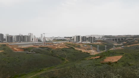 cámara caminando entre las colinas verdes en dirección a la vista del proyecto del puente de construcción