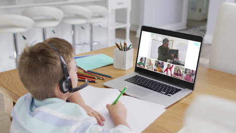 composite of boy using laptop for online lesson at home, with diverse teacher and class on screen