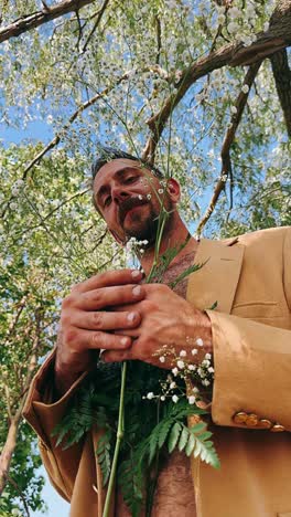 man with flowers under a tree