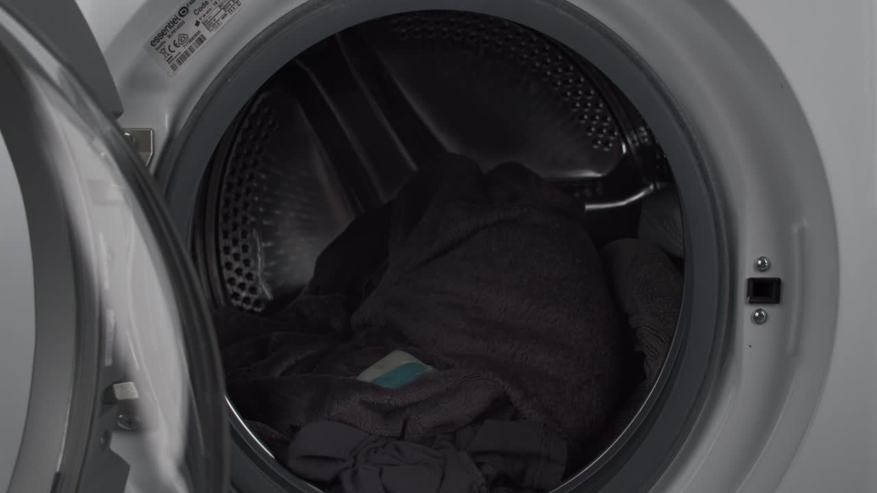 기계 부하 사전 세척에 세탁 세제를 추가하는 젊은 남자