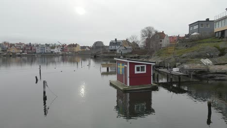 a close view of a picturesque little saunaraft with a swedish flag hanging outside, standing on still water in karlskrona, sweden