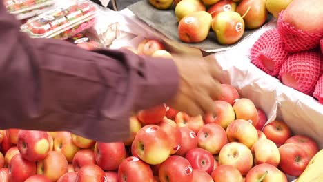 person picking apples at a market