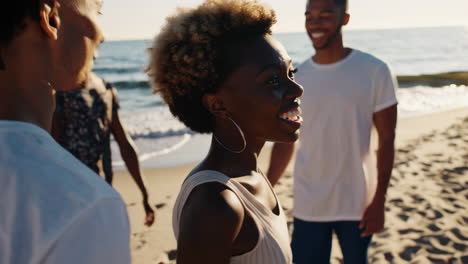 group of friends walking and laughing on the beach