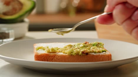 preparing avocado toast with cream cheese