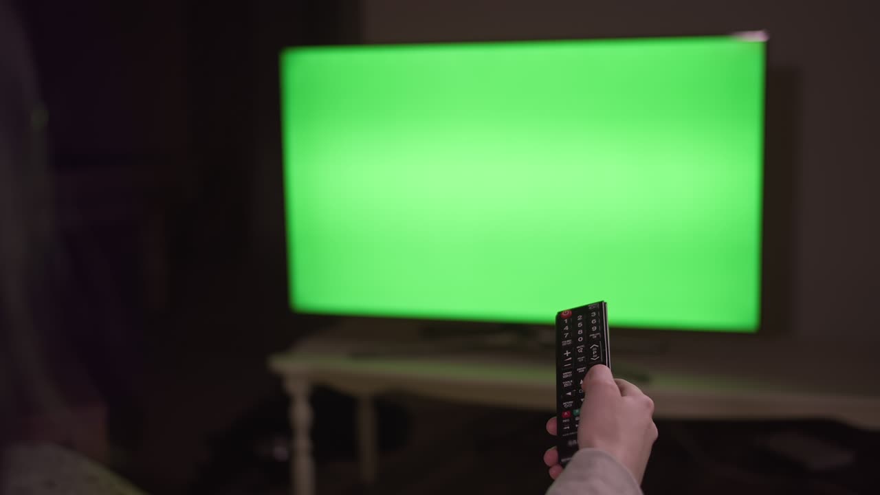 소녀는 리모컨의 버튼을 누르면 채널을 전환하고, 밤에는 tv에 앉습니다.