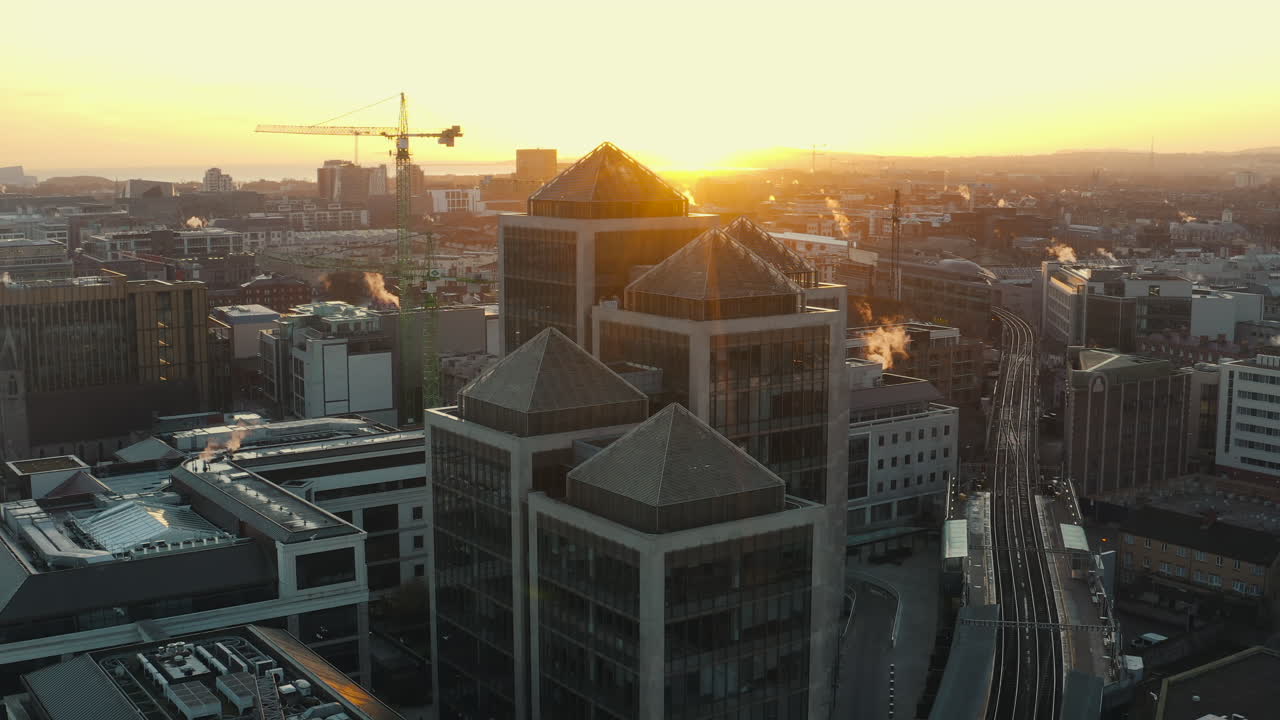 Aerial view over Dublin City at sunrise. Panning shot with the sun touching the top of buildings on a cold crisp winters morning.