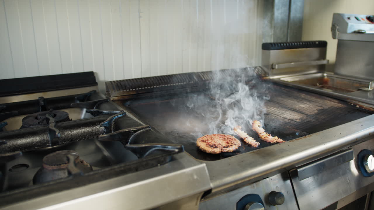 Meat Cooking On The Professional Kitchen Griddle And Releasing Smoke