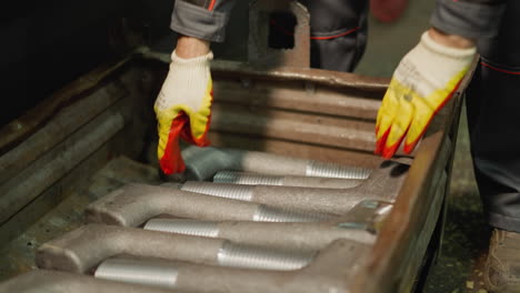 worker inspecting threaded metal rods in a workshop with industrial vibe