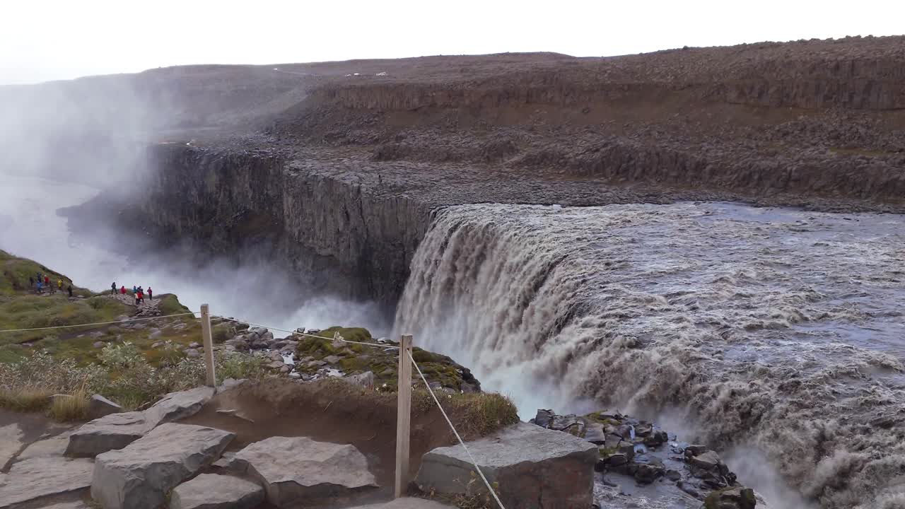 gente explorando la majestuosa y poderosa cascada de detifoss en islandia
