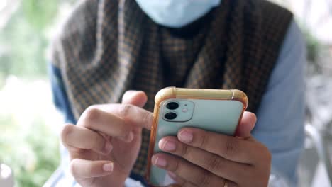 young women with face mask using smart phone sitting ,