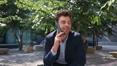 confident entrepreneur talking cellphone sitting sunny square smiling close up