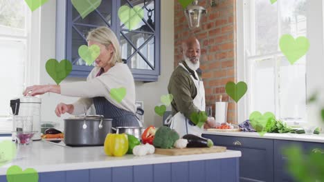 animación de iconos de corazón sobre varias parejas cocinando juntas