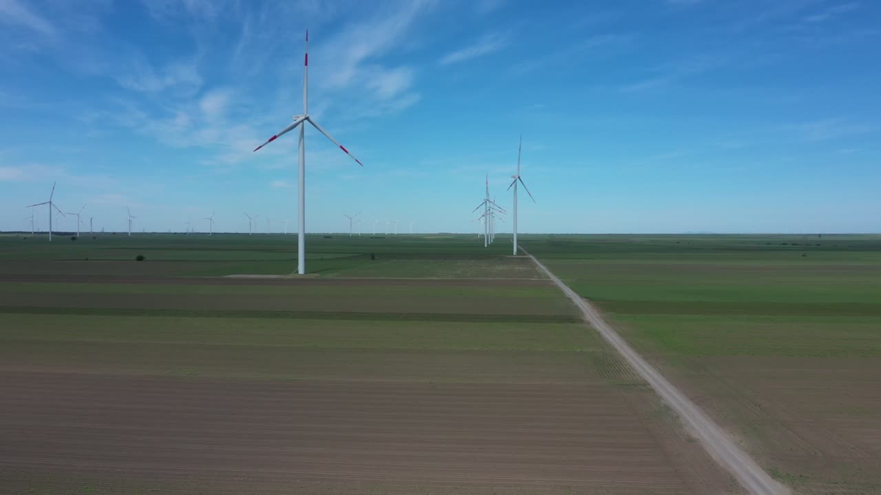 View of several windmills, wind generators, turbines, producing renewable clean energy by converting kinetic energy