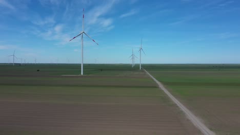 view of several windmills, wind generators, turbines, producing renewable clean energy by converting kinetic energy