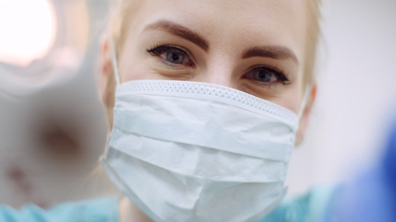 Крупный план: женщина-стоматолог смотрит на пациента во время операции