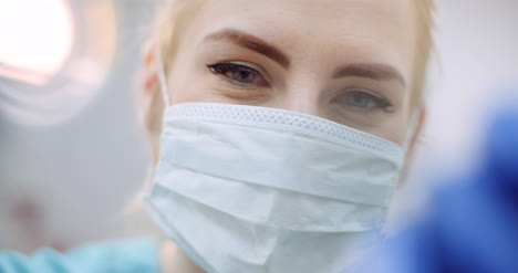 Close-Up-Of-Female-Dentist-Looking-At-Patient-During-Surgey