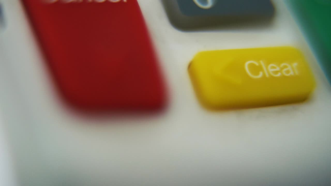 una ripresa macro di un pin pad, numeri e lettere su pulsanti colorati, movimento liscio verso il basso, video full hd, super slow motion, profondità di campo sfocata, cancellazione chiara