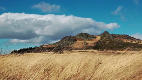 Rocky-mountain-formations-on-a-windy-day-with-golden-grass